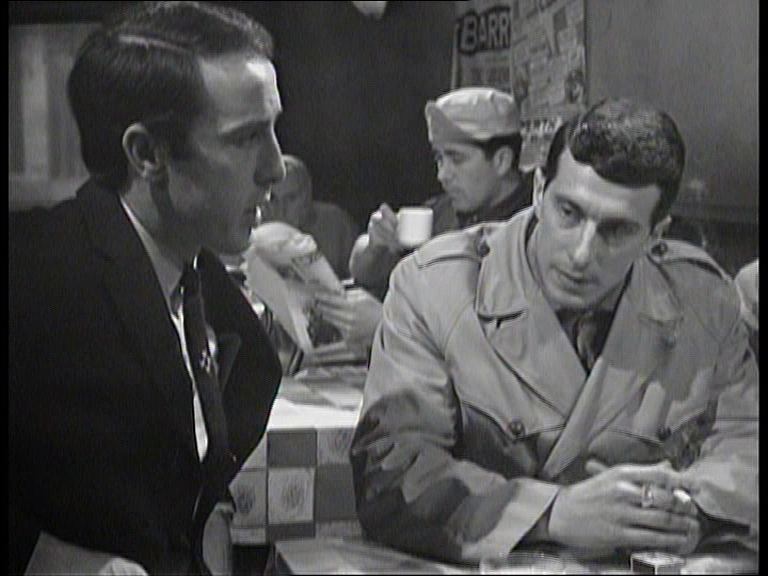 Toby at cafe table with Israeli secret service agent