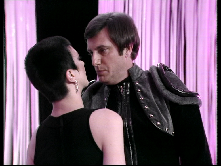 Servalan and Avon standing very close together