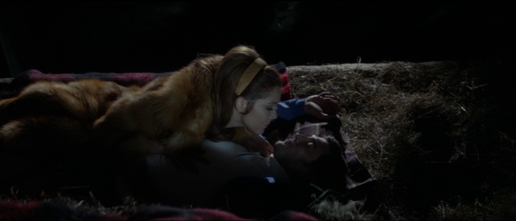 Tracy lying on top of Bond on a barn floor