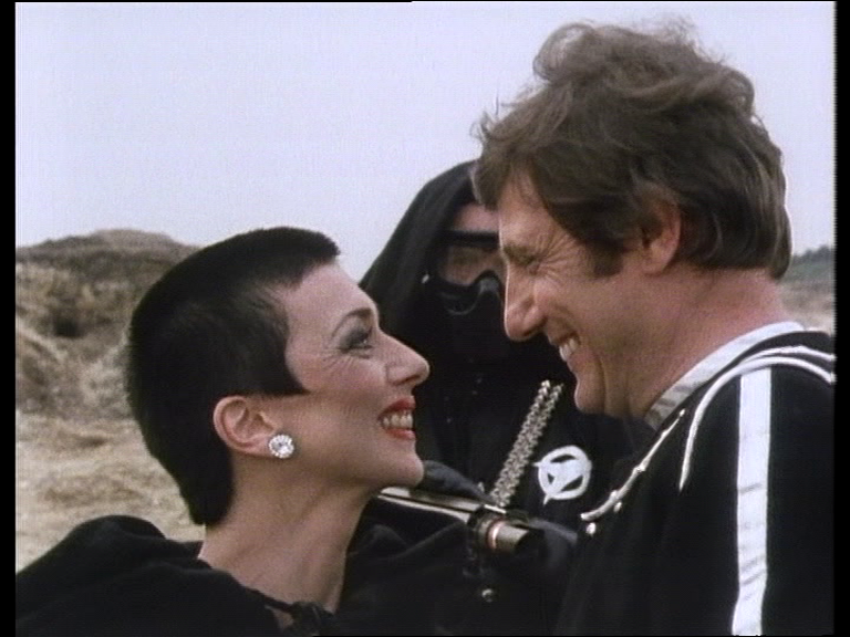 Servalan and Avon grinning and one another