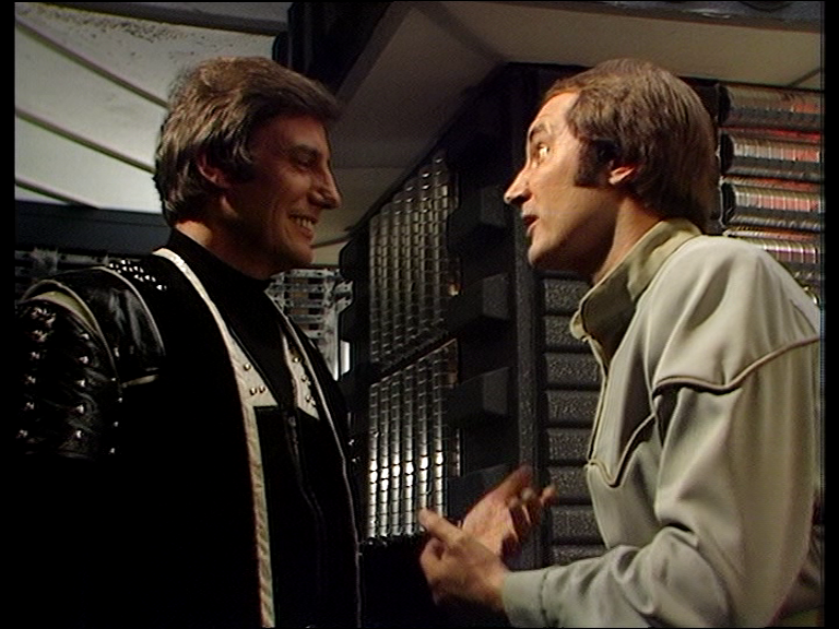 Avon grinning at argumentative Vila in the airlock face to face