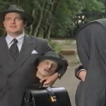 flynn holding a body over his shoulder while niven holds the head