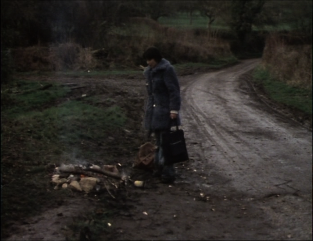 jenny stares at the recently extinguished and still smouldering fire