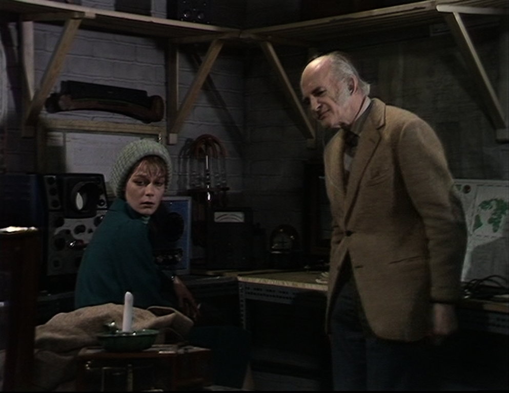 abbey and the school master stare at a simple candle and metal holder