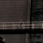 female figure running along bridge