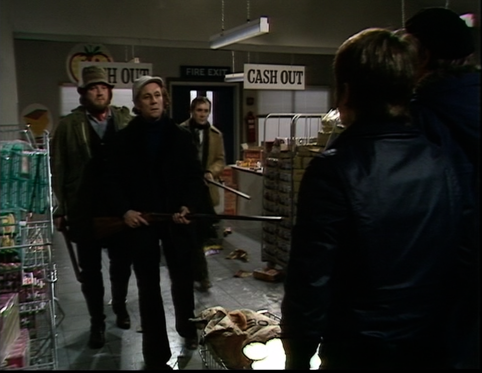 Wormley's gang hold shotguns inside the supermarket and stare down Abby