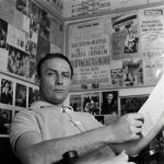 Edward Woodward relaxing at home and reading what looks like a script