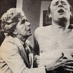 The doctor holds Callan's ribs as he closes his eyes, open mouthed in pain