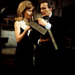 Caroline and Callan in the gun room as he hands her the negatives from grey box file