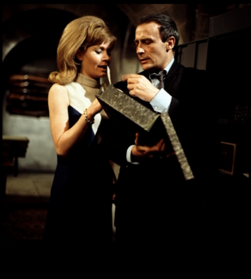 Ann and Callan in the gun room as he hands her the negatives from grey box file