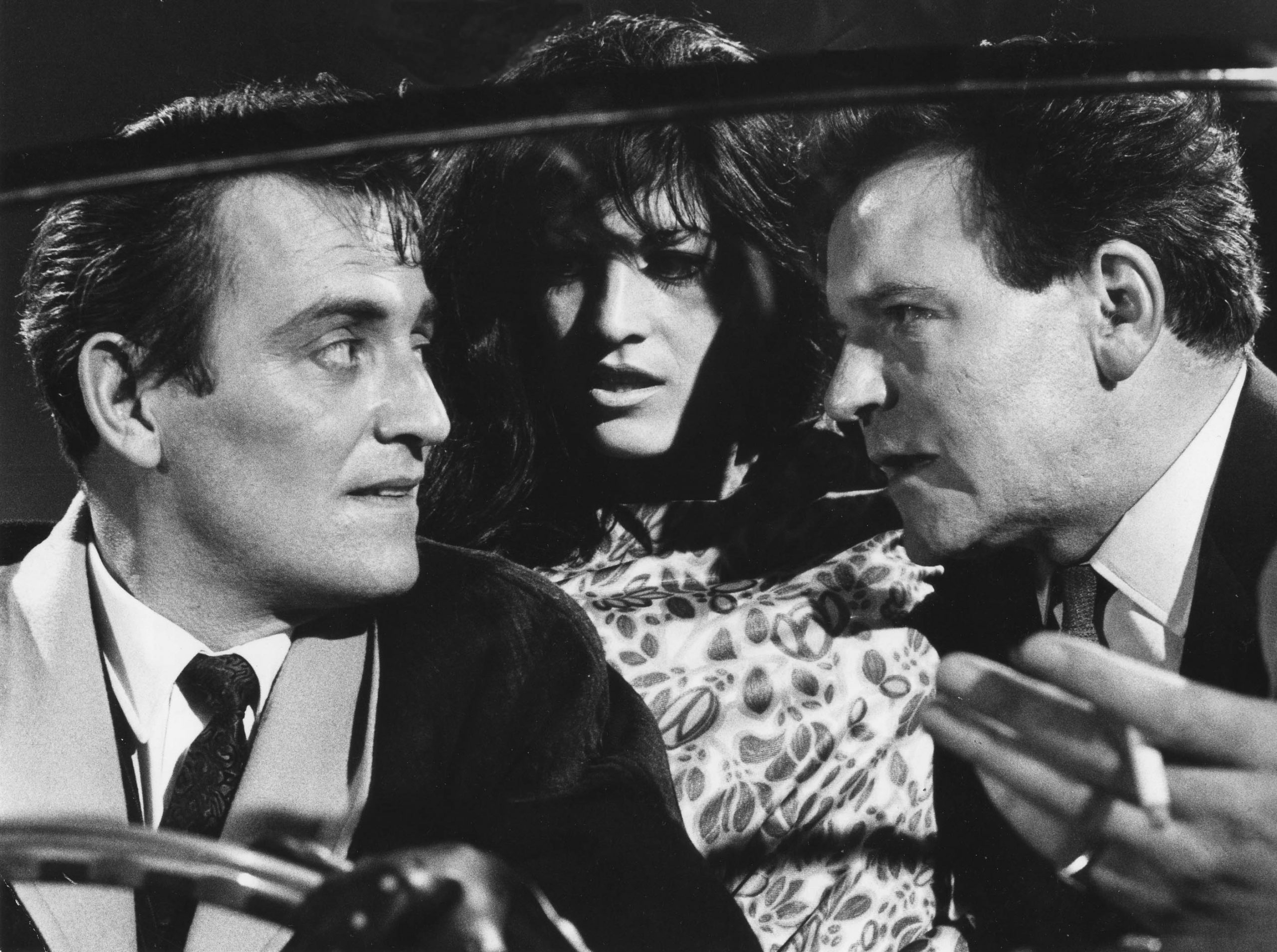 Gerald Floor and Glyn Owen in the front of a car with a young woman sat between them