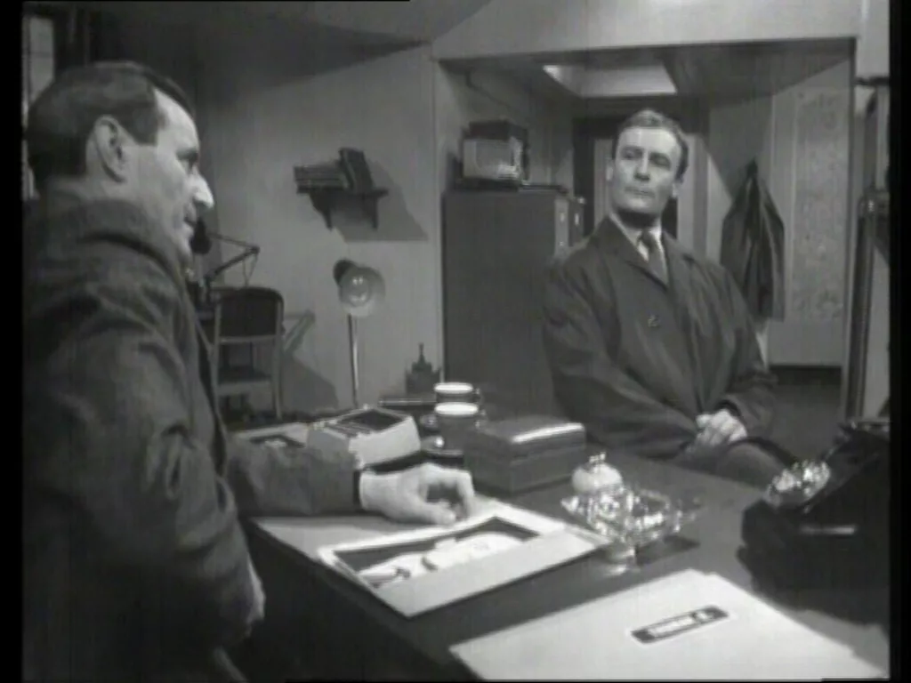 Callan and Hunter both face each other warily in Hunter's office